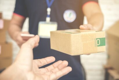 delivery-man-smiling-holding-cardboard-box_1150-8869